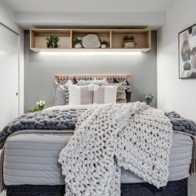 Beautiful bedrooms to fit every need a bedroom with a bed and a shelf with pictures on it